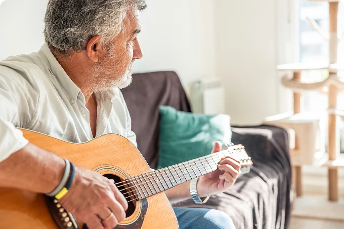 Senior man playing guitar at home in a relaxed and peaceful setting