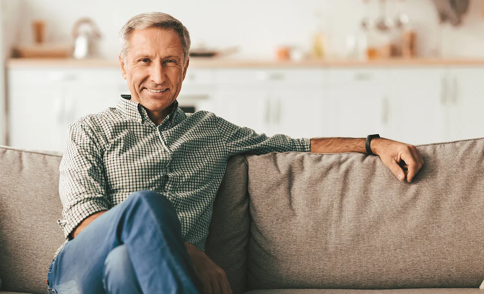 Portrait of a senior man seated on a couch in a cozy home setting